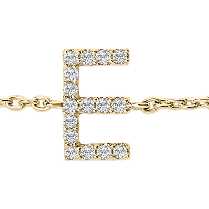 Close-up front angle of a yellow metal bracelet featuring a letter 'E' pendant adorned with round white gemstones in micro-pave setting, shown lying flat.