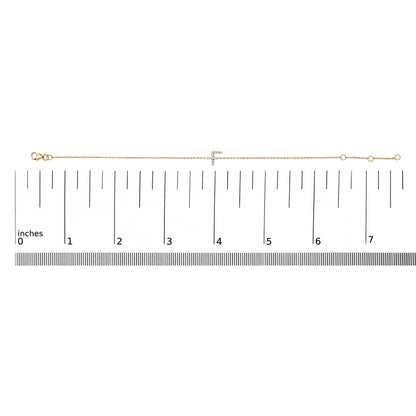 Yellow bracelet with a chain and a horizontal bar encrusted with small white gemstones in micro-pave setting, displayed flat on a measurement scale, top-down view.