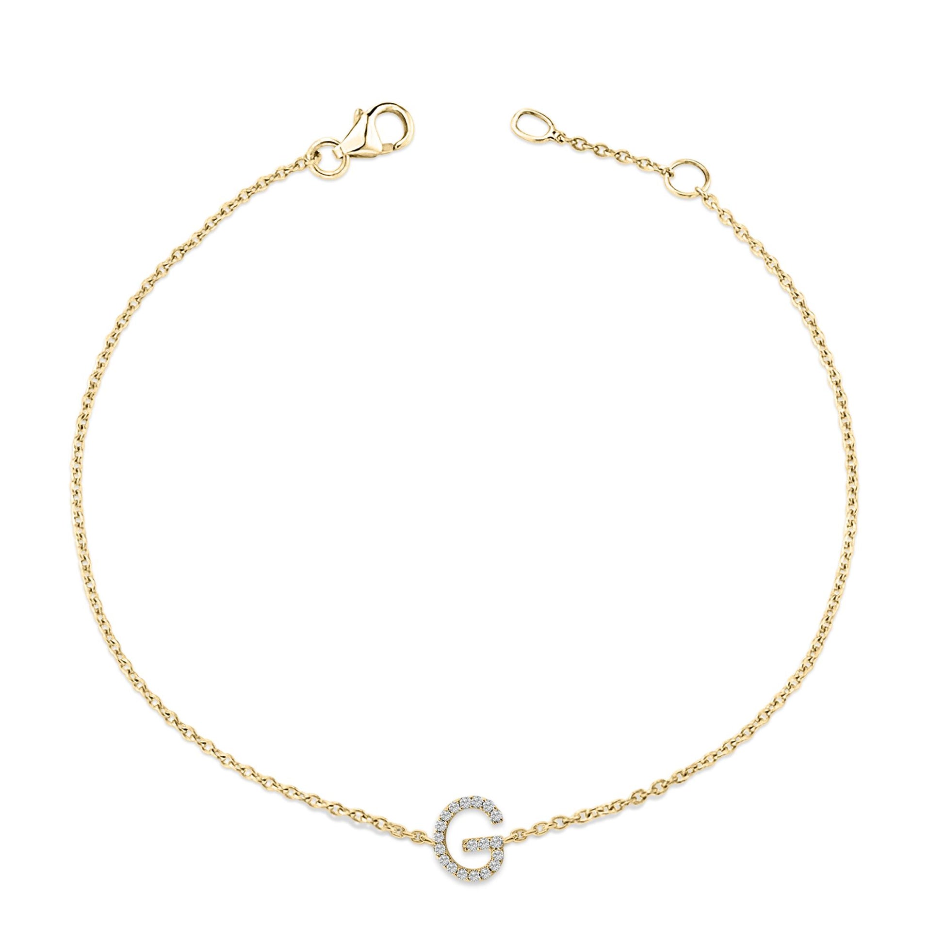 Yellow metal bracelet with a circular link chain and a central letter-shaped charm embellished with small white gemstones, shown flat from a top-down angle.