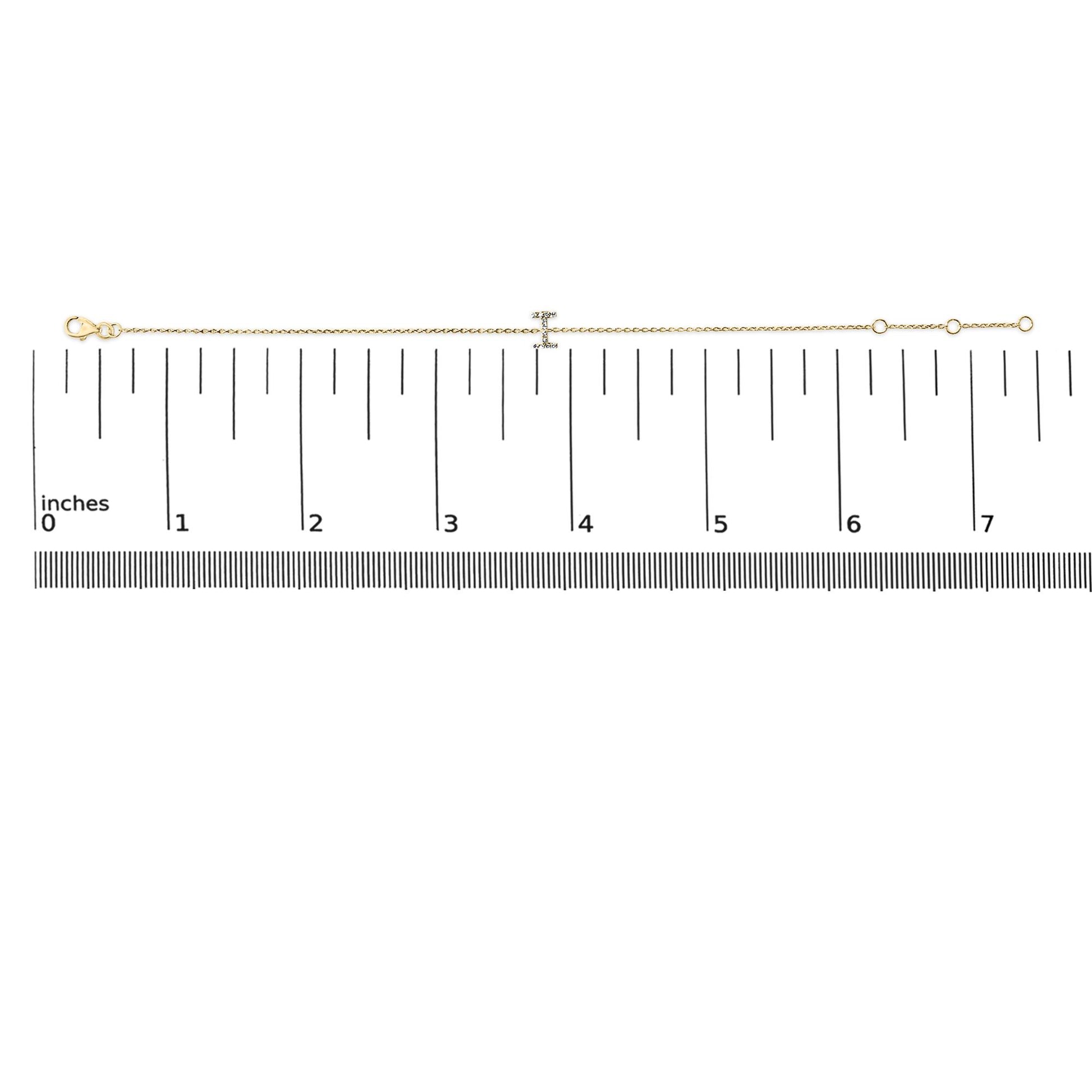 Bracelet with a fine yellow chain and a central bar set with small white gemstones in a micro-pave setting, shown laid flat on a measurement scale, top-down view.