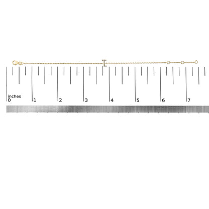 Bracelet with a fine yellow chain and a central bar set with small white gemstones in a micro-pave setting, shown laid flat on a measurement scale, top-down view.
