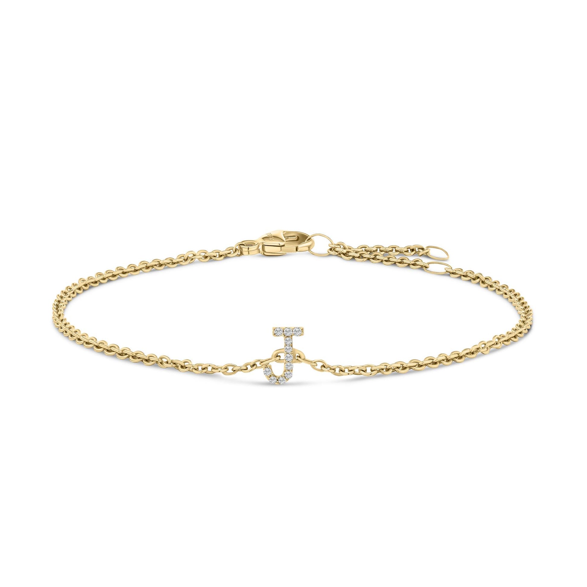 Yellow metal bracelet with a delicate chain and a letter 'J' charm embellished with small white gemstones, shown in a front-facing flat lay angle.