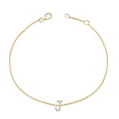 Top-down view of a yellow metal bracelet with a chain design and an initial letter charm adorned with white round gemstones in a micro-pave setting.