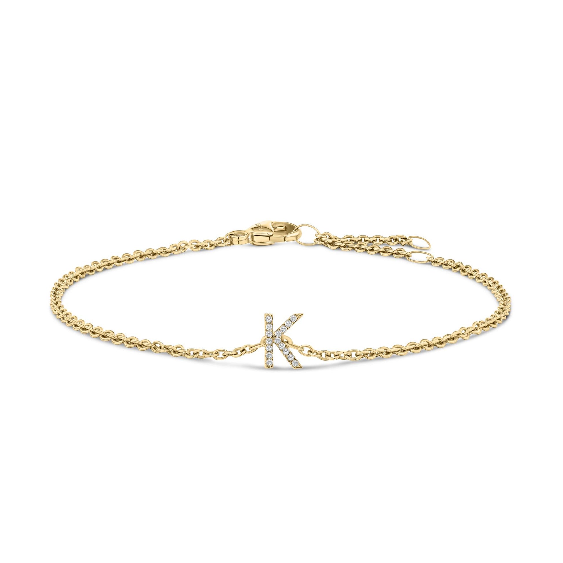 Yellow metal bracelet with a chain design and a letter 'K' centerpiece adorned with white gemstones, shown from a top-down angle on a white background.