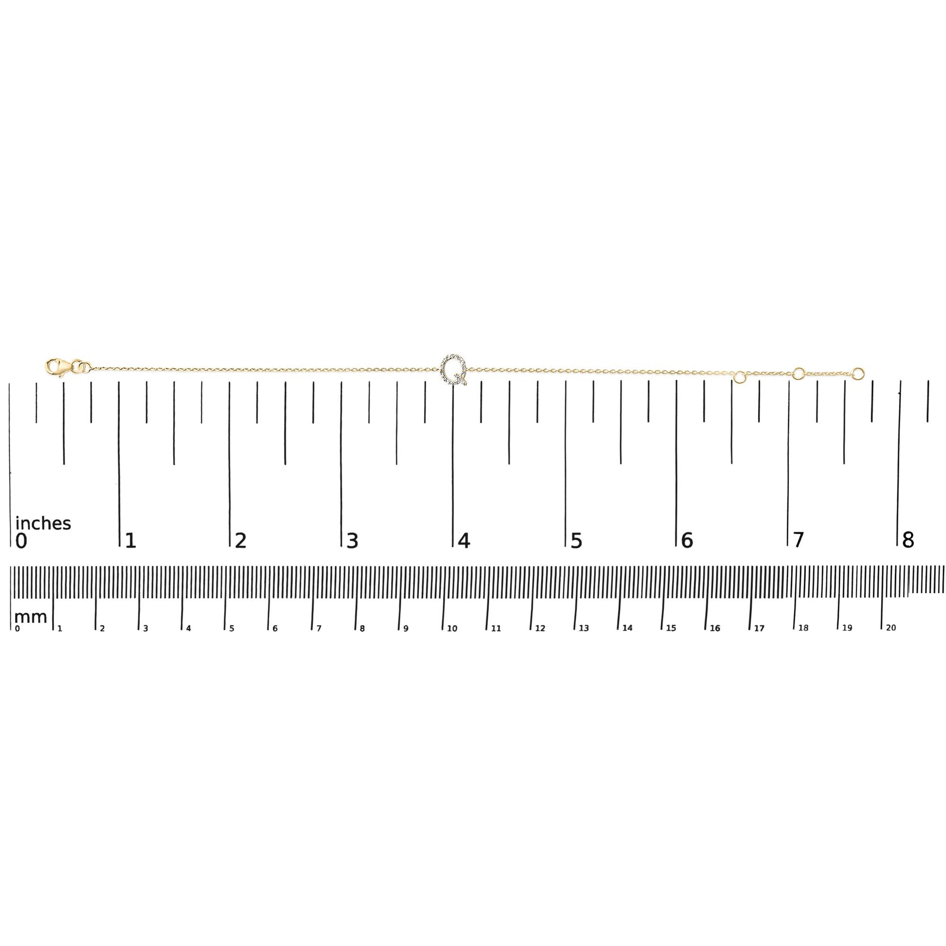 Yellow metal delicate bracelet with a small circular centerpiece set with white gemstones, shown laid flat on a scale, top-down view.