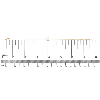 Yellow metal delicate bracelet with a small circular centerpiece set with white gemstones, shown laid flat on a scale, top-down view.
