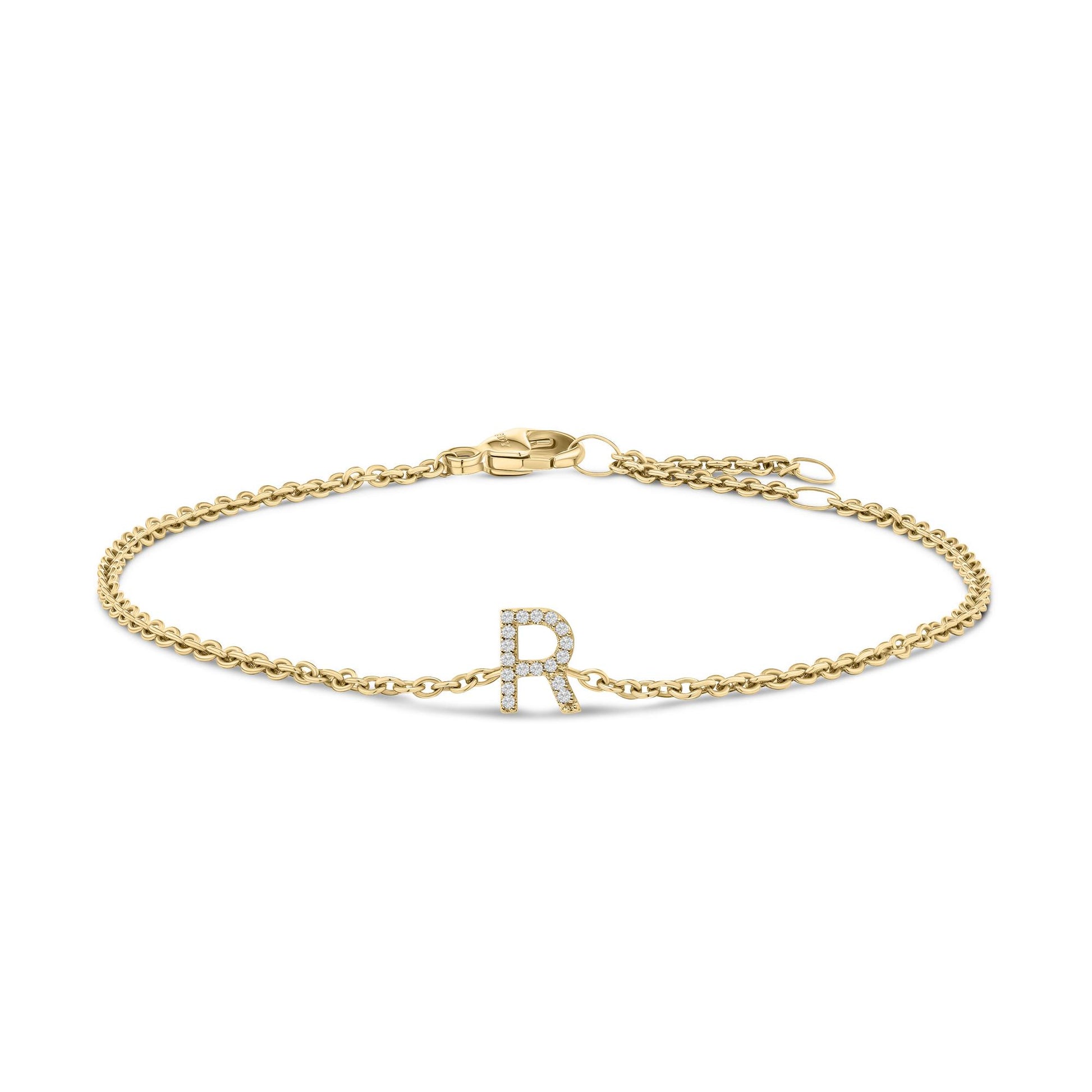 Close-up front angle of a yellow metal bracelet with a chain and a central letter 'R' adorned with small white gemstones in a micro-pave setting, shown on a white background.