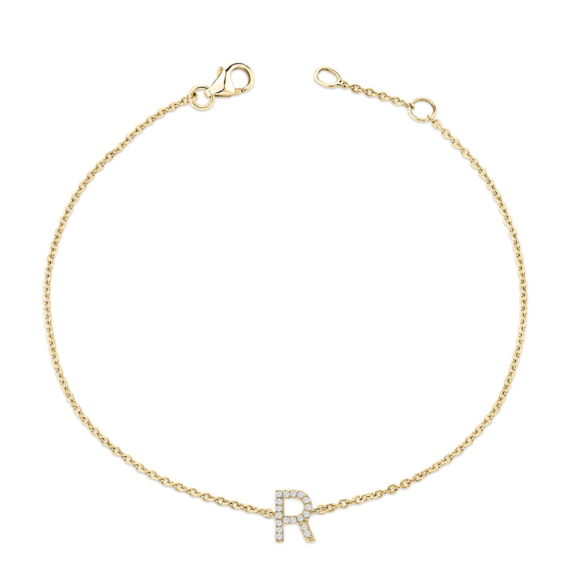 Yellow metal bracelet with a chain design and a central letter 'R' embellished with small white gemstones, shown from a top-down angle on a white background.