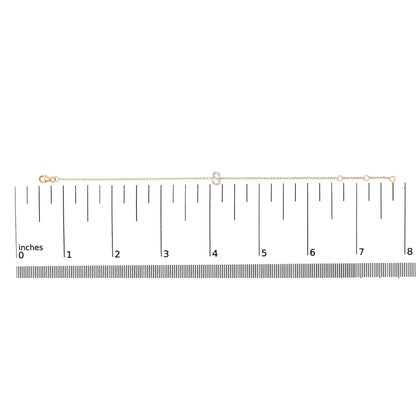 Thin yellow bracelet with a small curved centerpiece set with white round gemstones in a micro-pave style, shown flat on a ruler from a top-down angle.