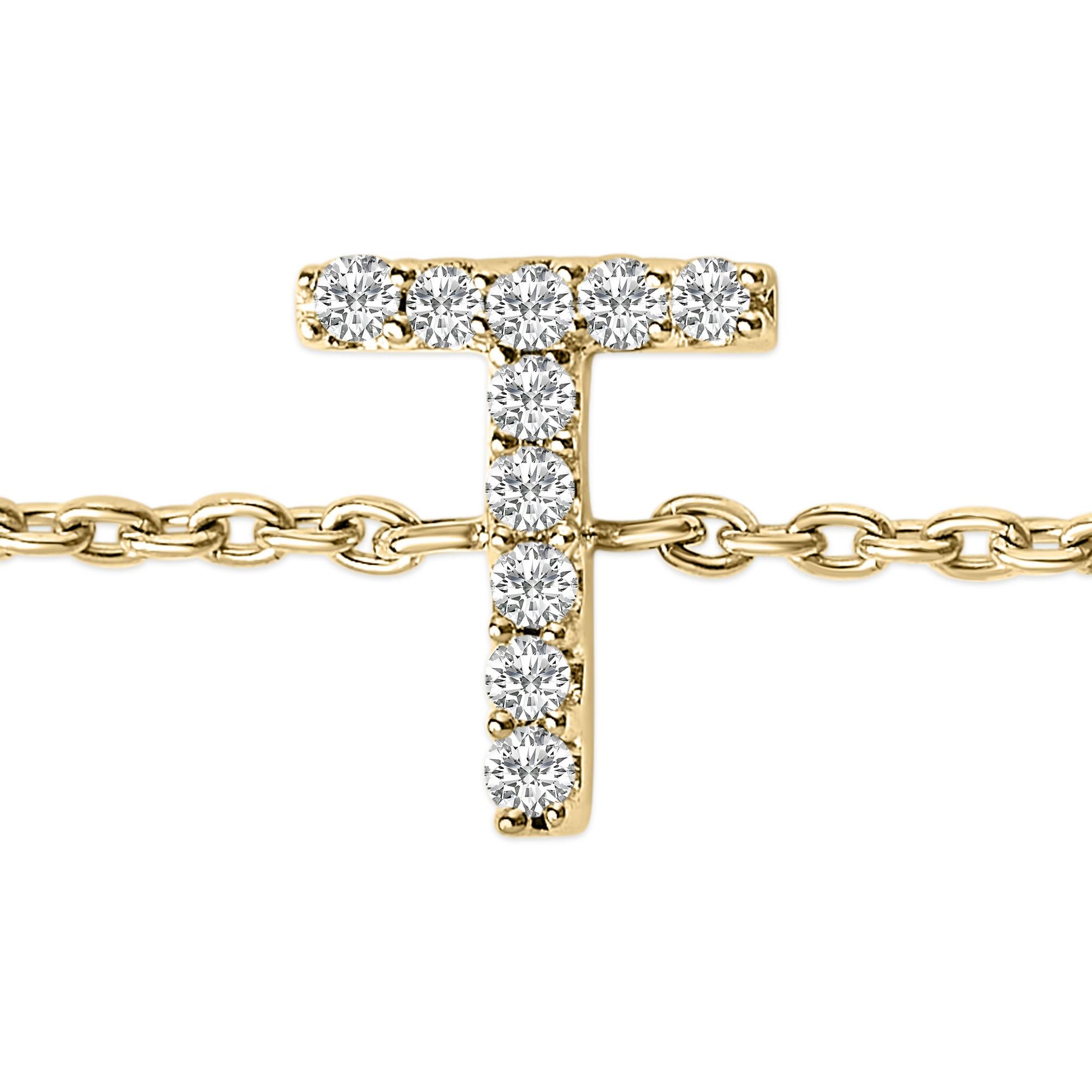 Close-up front view of a yellow metal bracelet with a T-shaped charm set with white round gemstones in a micro-pave setting, shown on a chain.