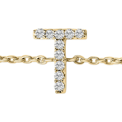 Close-up front view of a yellow metal bracelet with a T-shaped charm set with white round gemstones in a micro-pave setting, shown on a chain.