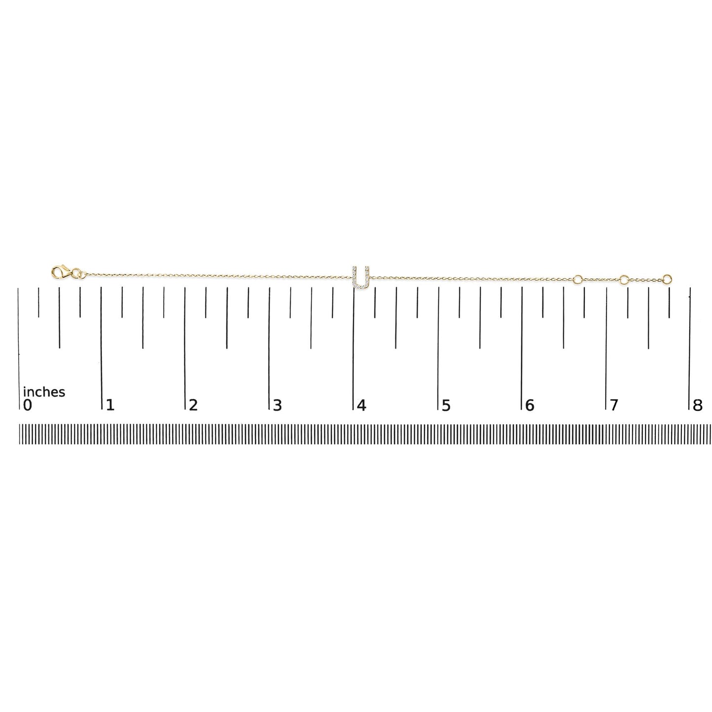 Yellow bracelet with chain and U-shaped centerpiece featuring white gemstones in a micro-pave setting, shown flat on a scale from above.