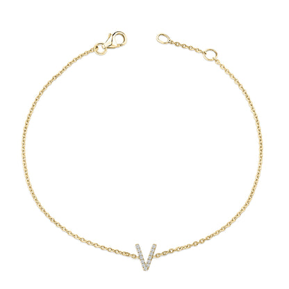 Top-down view of a yellow bracelet with a chain and a V-shaped accent set with small white gemstones in a micro-pave setting.