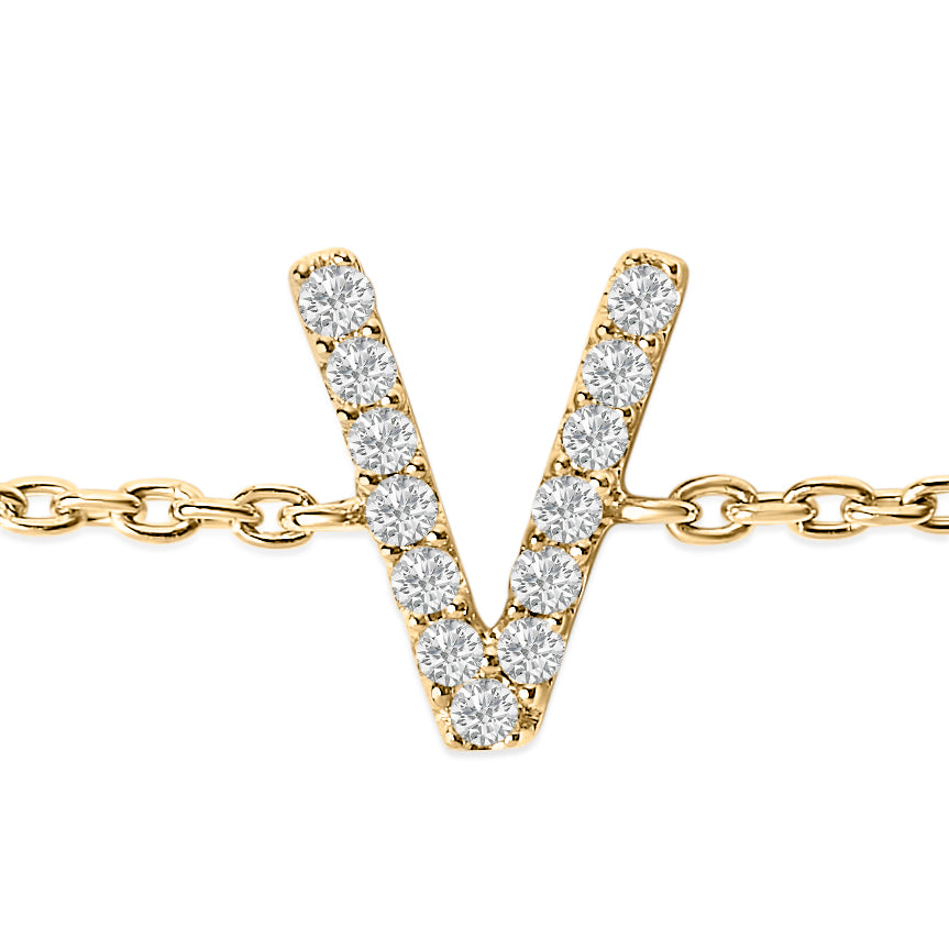 Close-up front view of a yellow metal bracelet with a V-shaped charm set with white round gemstones in a micro-pave setting, shown on a white background.