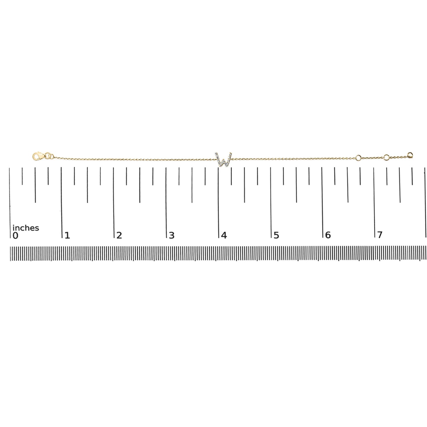 Yellow metal bracelet with a central 'W' initial accented by white gemstones in a micro-pave setting, shown laid flat on a ruler scale from a top-down angle.
