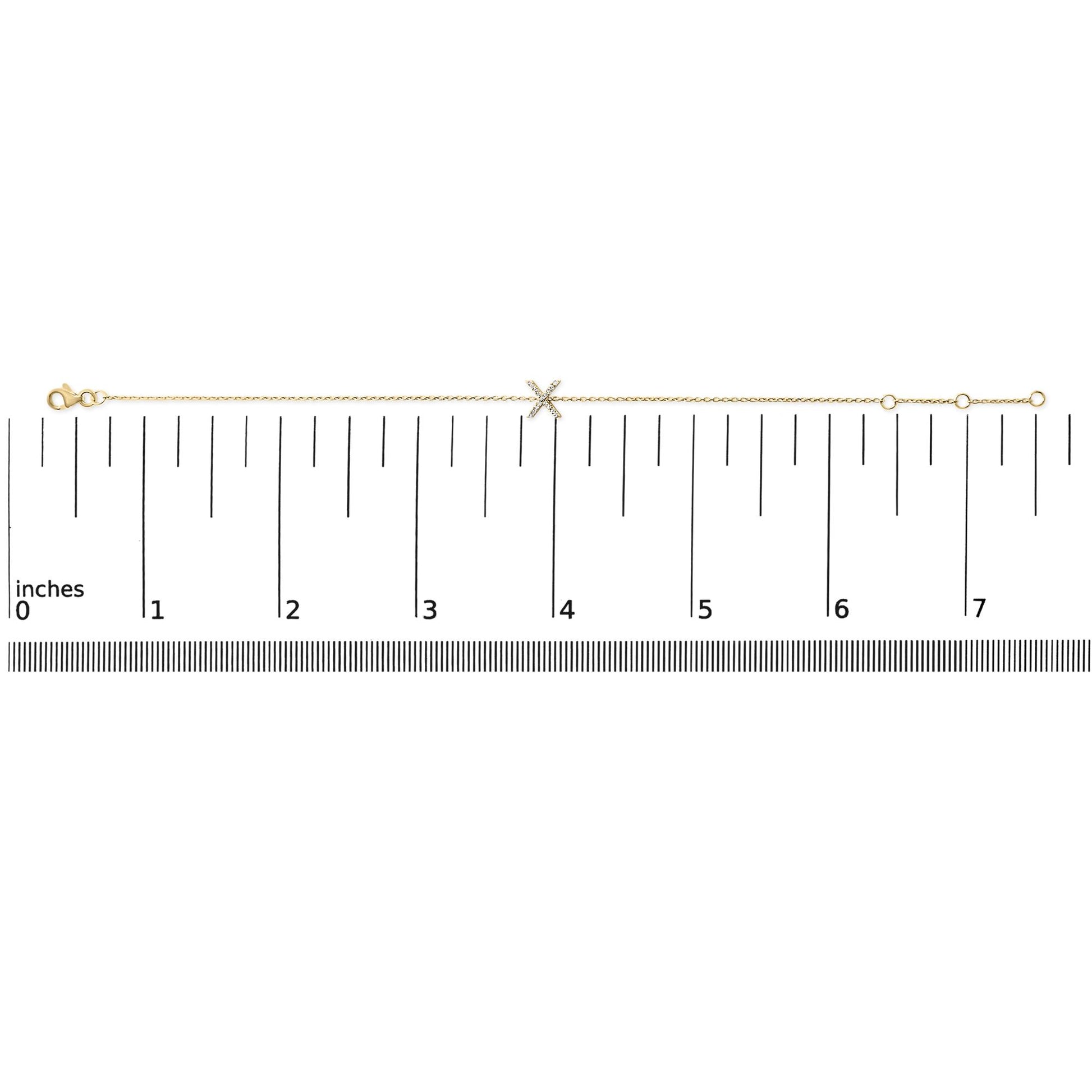 Yellow bracelet with an 'X' shaped centerpiece adorned with small white gemstones in a micro-pave setting, shown flat on a scale from a top-down angle.