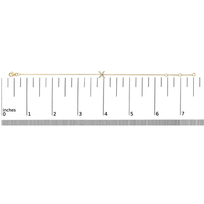 Yellow bracelet with an 'X' shaped centerpiece adorned with small white gemstones in a micro-pave setting, shown flat on a scale from a top-down angle.
