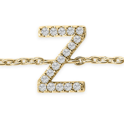 Close-up front view of a yellow metal bracelet featuring a pendant in the shape of the letter Z adorned with white round gemstones in a micro-pave setting, shown against a white background.
