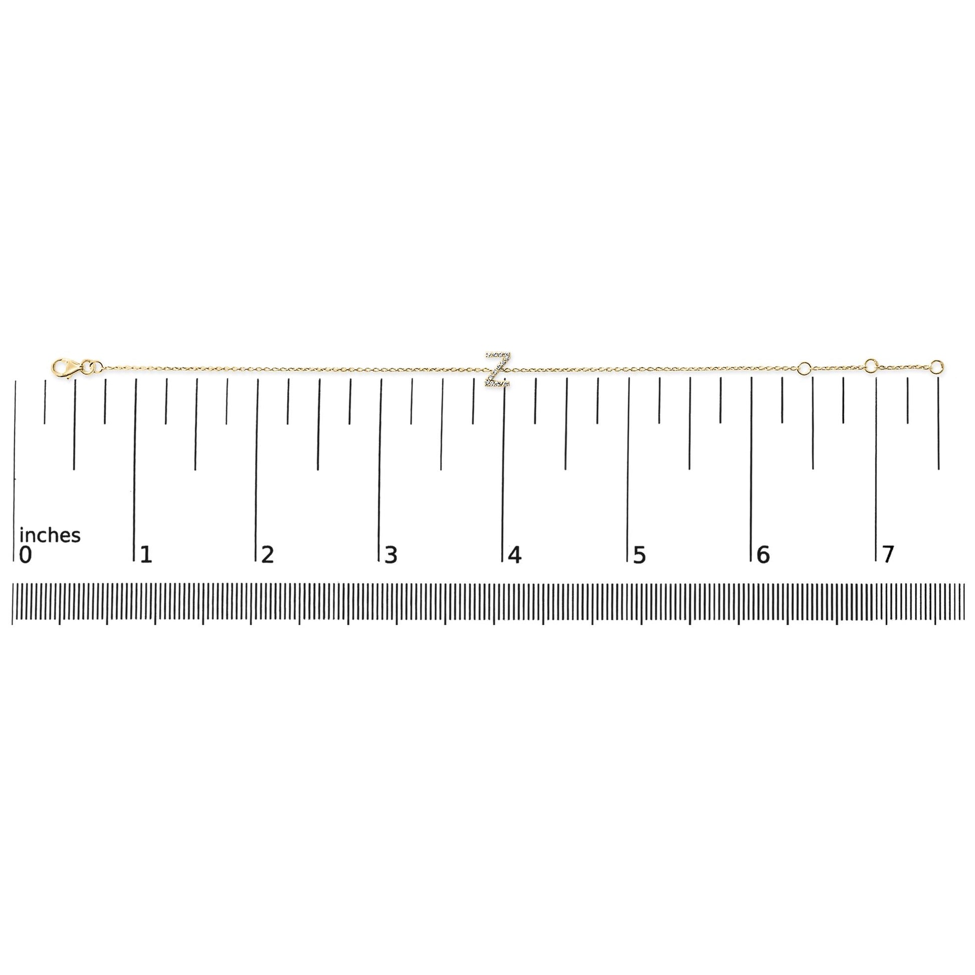 Yellow metal bracelet with a letter 'Z' charm set with white round gemstones in micro-pave setting, displayed flat on a scale, top-down view.