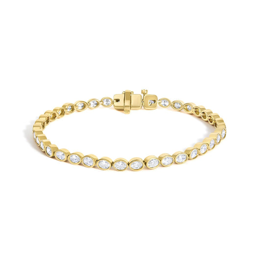Front view of 14K yellow gold oval diamond tennis bracelet with east west bezel settings and clasp on white background