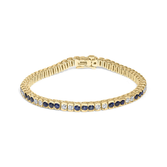 Yellow metal bracelet with alternating round blue and white gemstones in bezel settings, shown from a slightly angled top view.