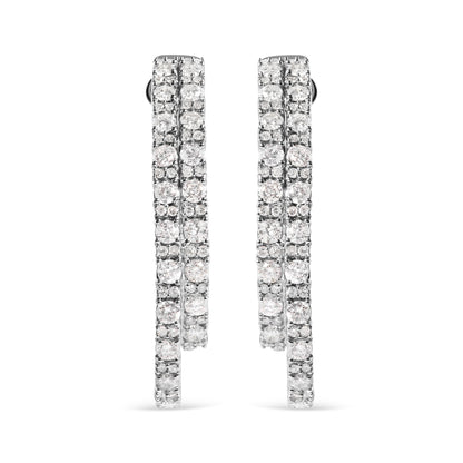 Front-facing view of a pair of white metal hoop earrings encrusted with multiple rows of round white gemstones in a prong setting.