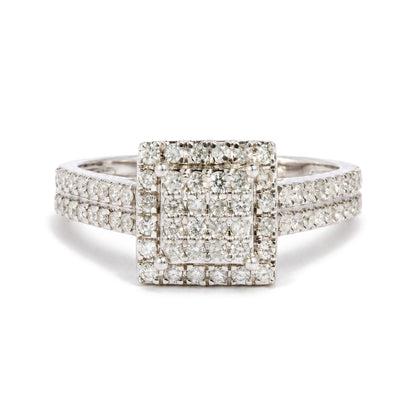 Close-up front view of a white metal ring featuring a square cluster of round white gemstones in prong settings, with rows of similar gemstones detailing the band.