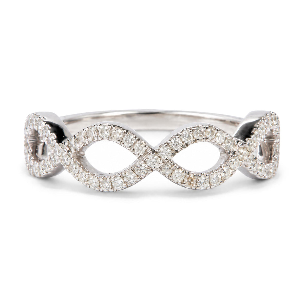Close-up front angle of a white metal ring with two interlocking oval shapes, each paved with round white gemstones in prong settings.