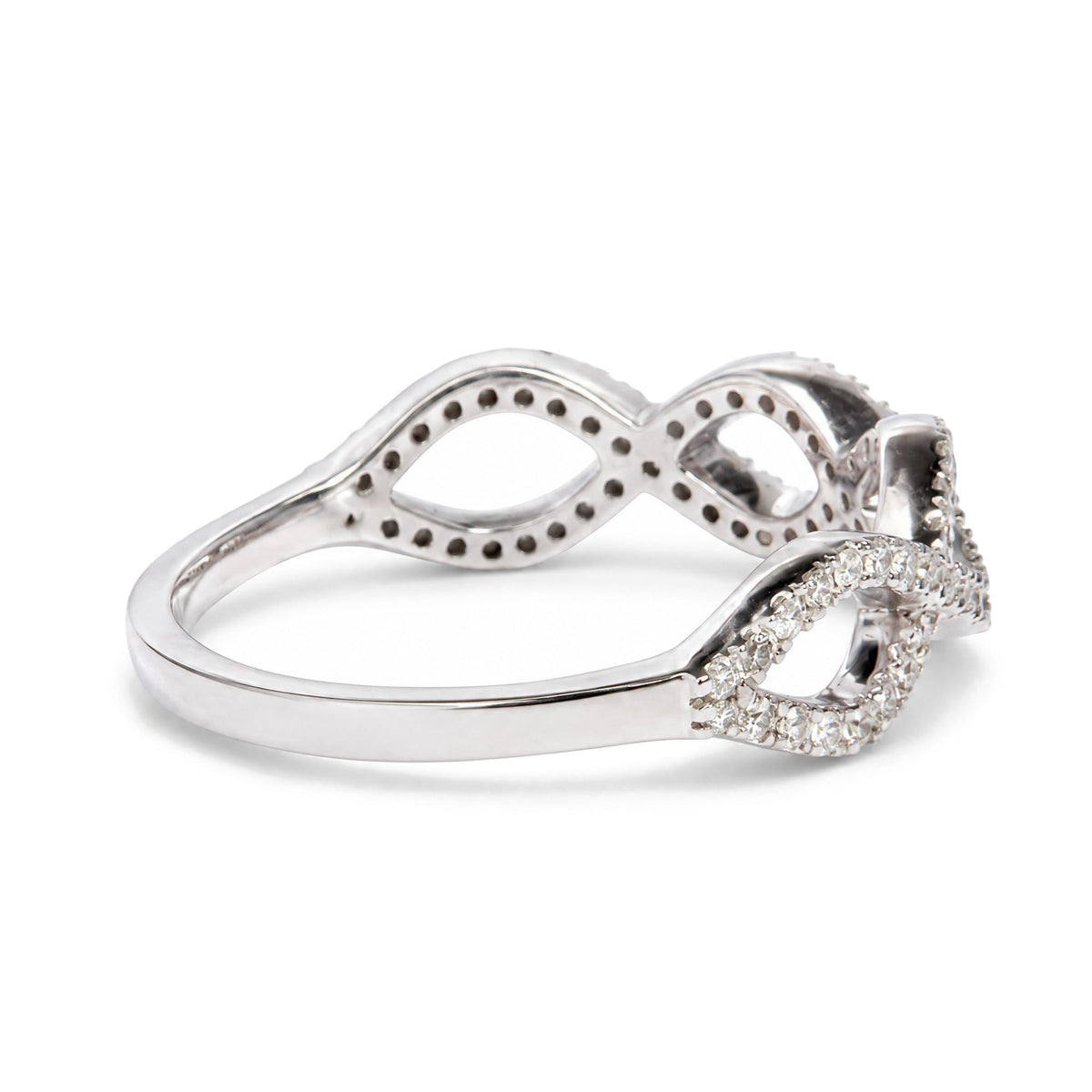 Close-up side angle of a white metal ring with an open twisted design, featuring a row of small white gemstones in prong settings along part of the band.
