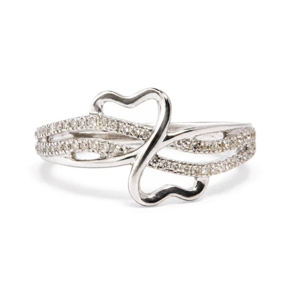 Close-up front angle of a white metal ring with an open heart shape and three intersecting bands adorned with multiple round white gemstones in prong settings, shown on a white background.