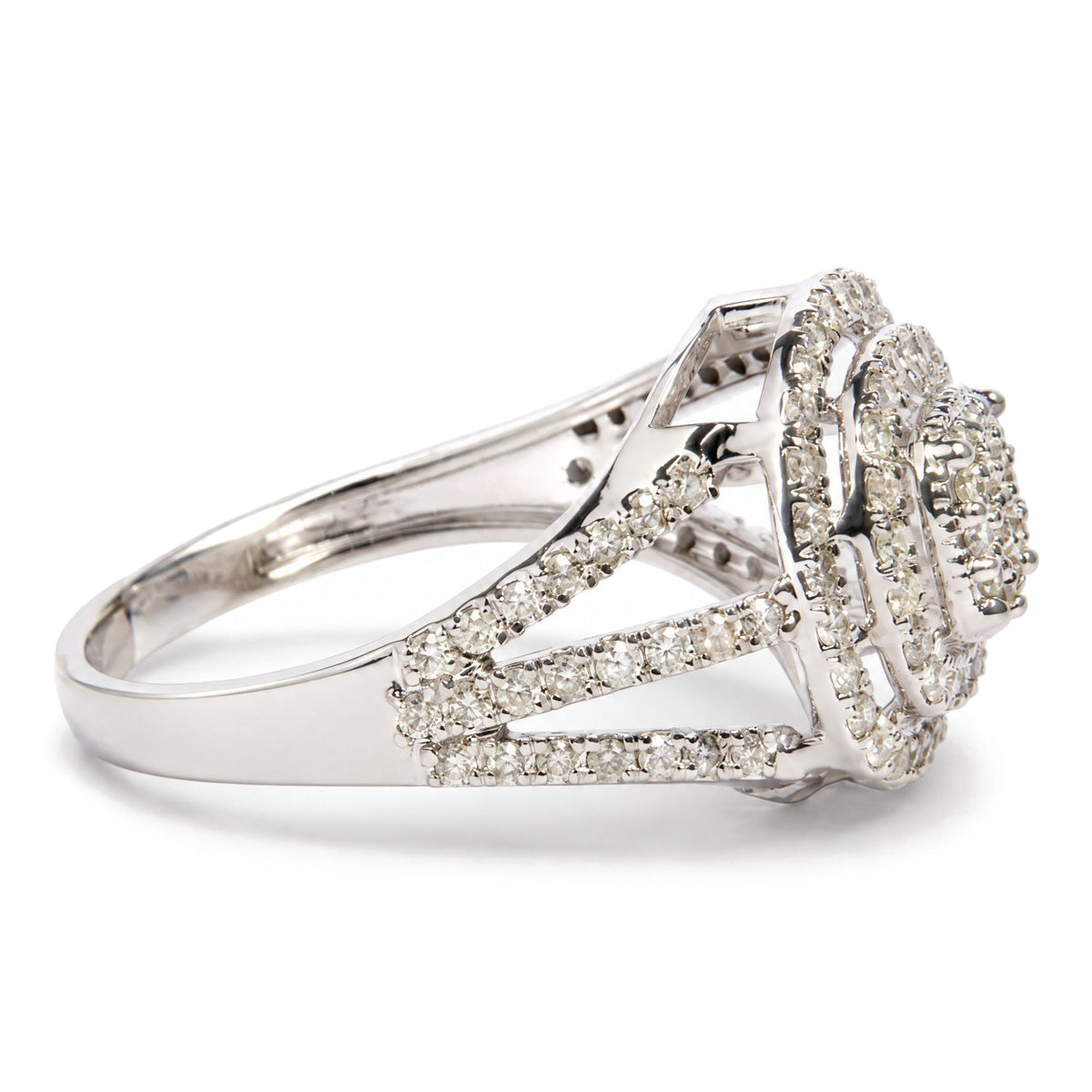 Close-up side angle of a white ring with an intricate openwork design featuring multiple rows of prong-set round white gemstones.