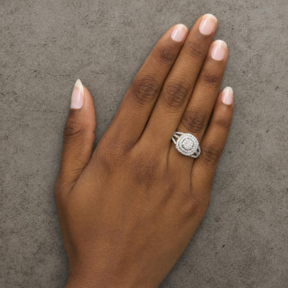 Close-up angle of a model's hand wearing a white ring with multiple round white gemstones in prong settings arranged in concentric circular patterns.