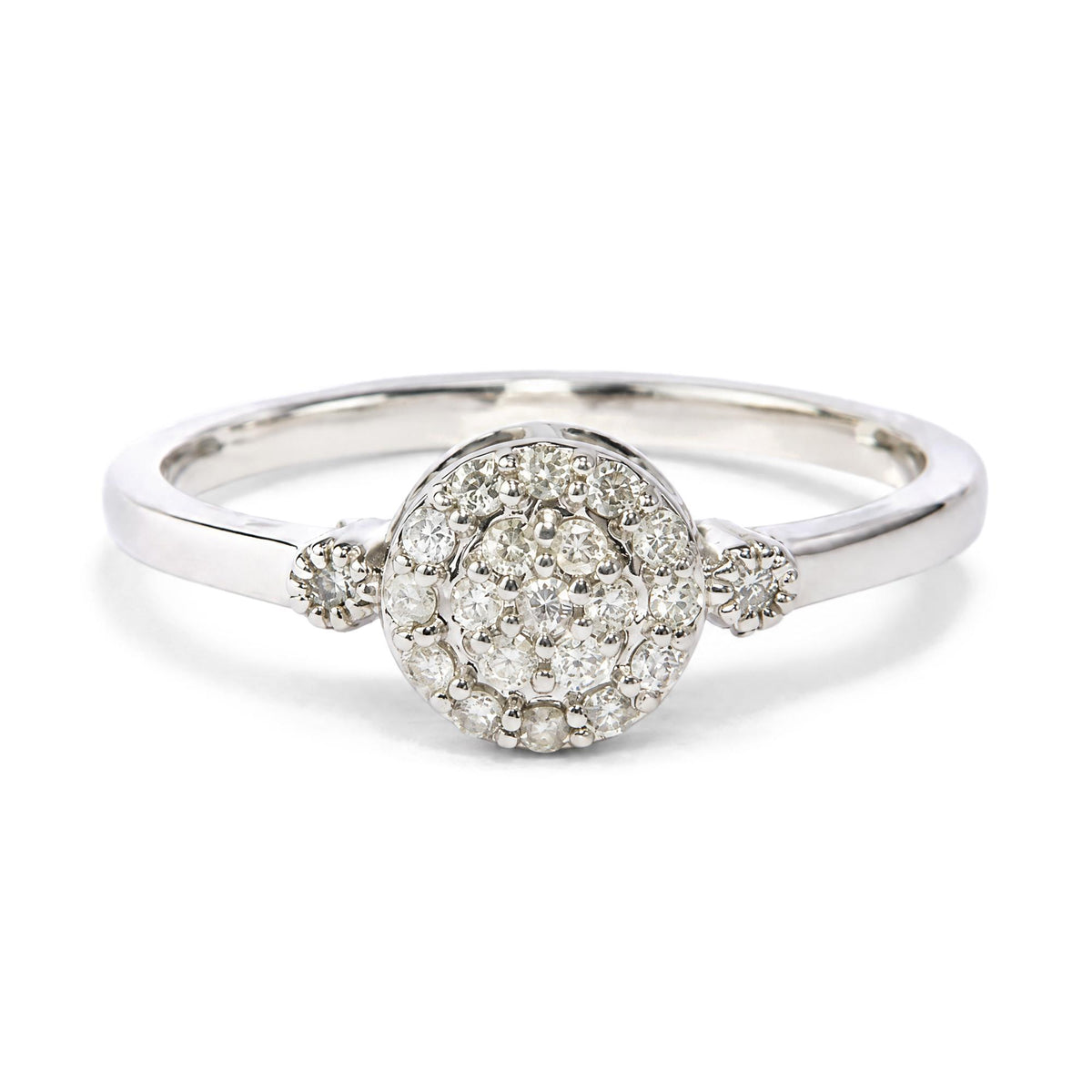 Close-up front angle of a white metal ring featuring a cluster of round white gemstones in prong settings at the center.