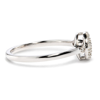 Close-up side angle of a white metal ring with a cluster of round white gemstones in prong settings on the top.