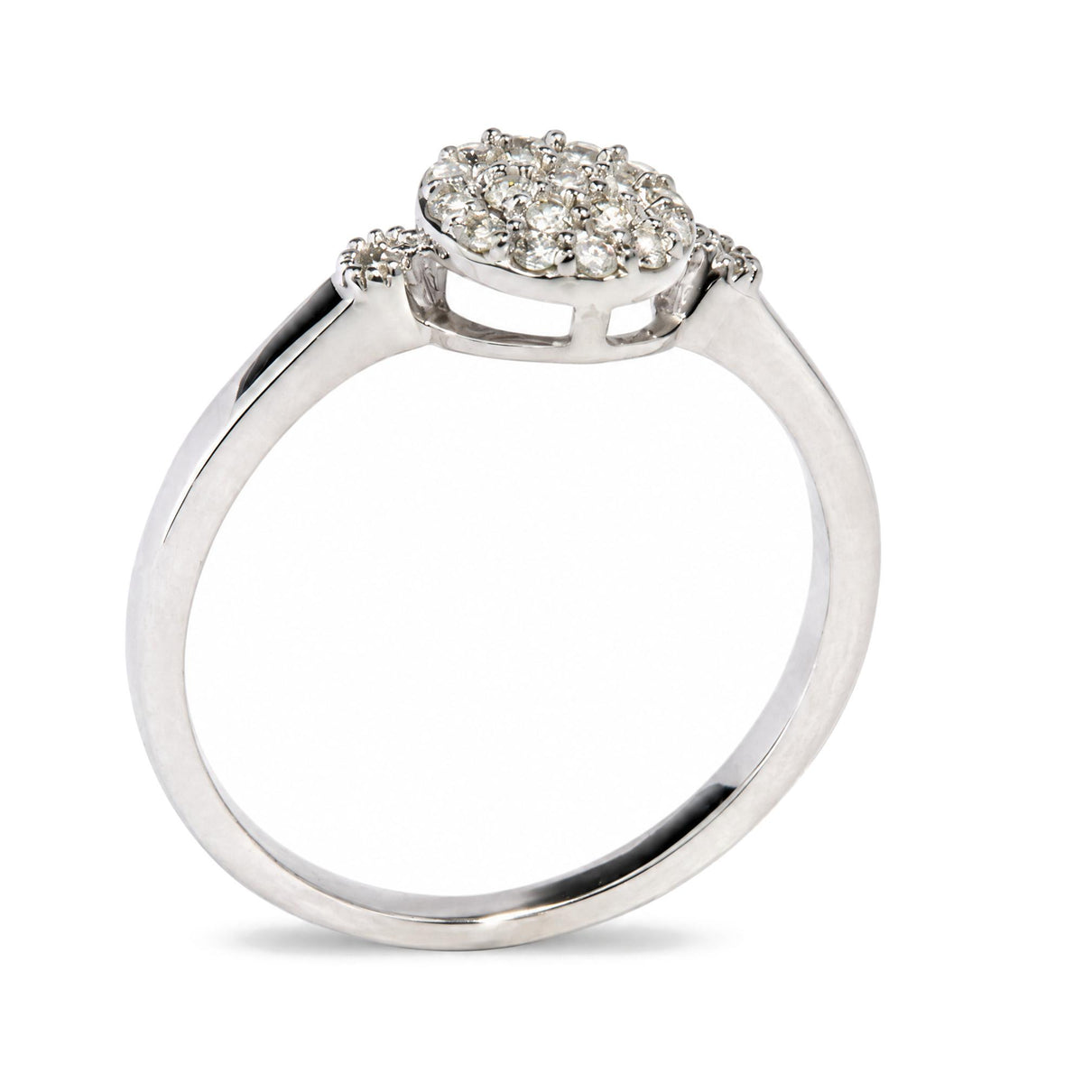 Close-up front angle of a white metal ring featuring a cluster of round white gemstones in prong settings on the top.
