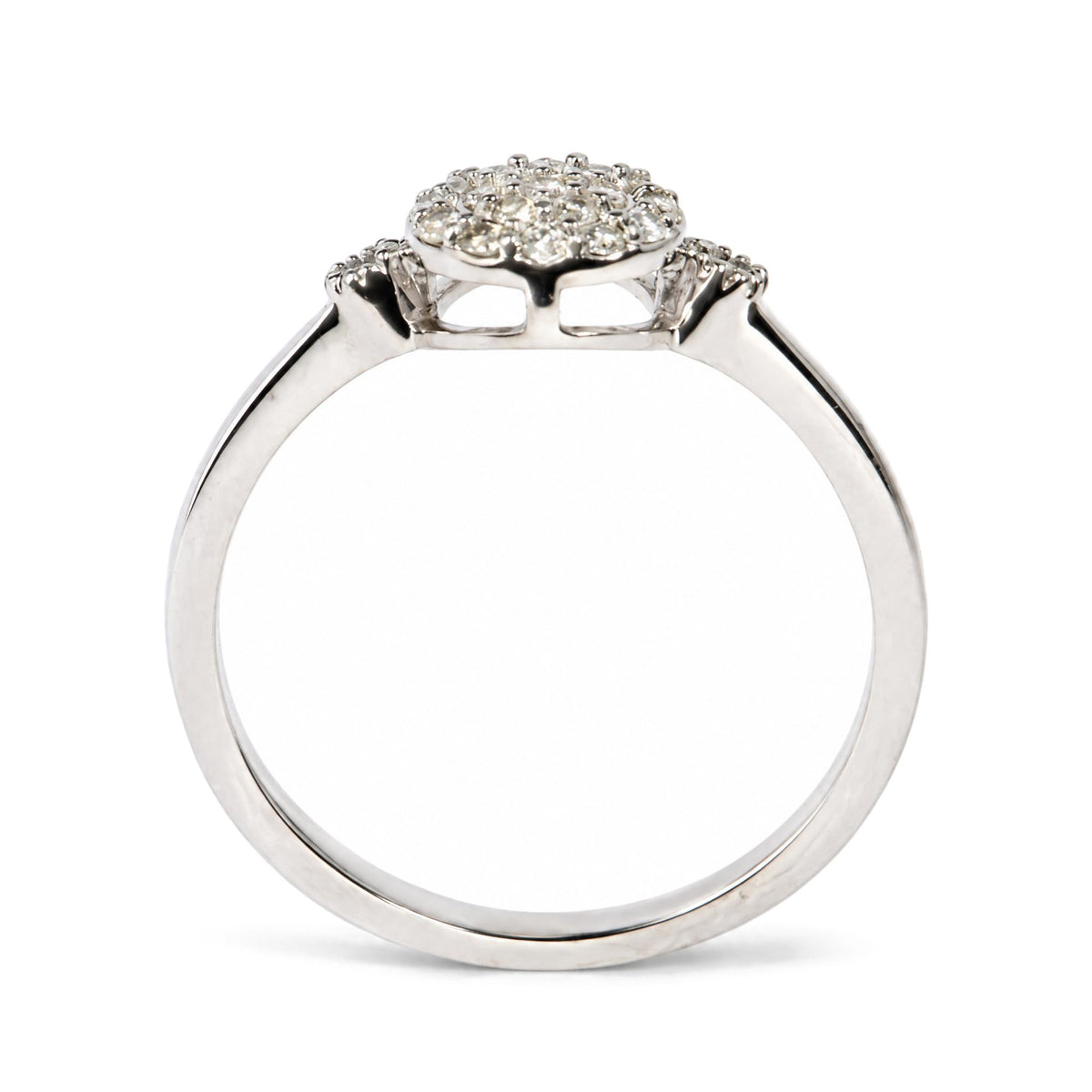 Close-up side view of a white ring with a halo cluster of round white gemstones in prong settings on top.