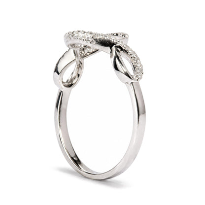 Close-up front angle of a white metal ring with a crossover design featuring round white gemstones in prong settings along the top curve, shown on a white background.
