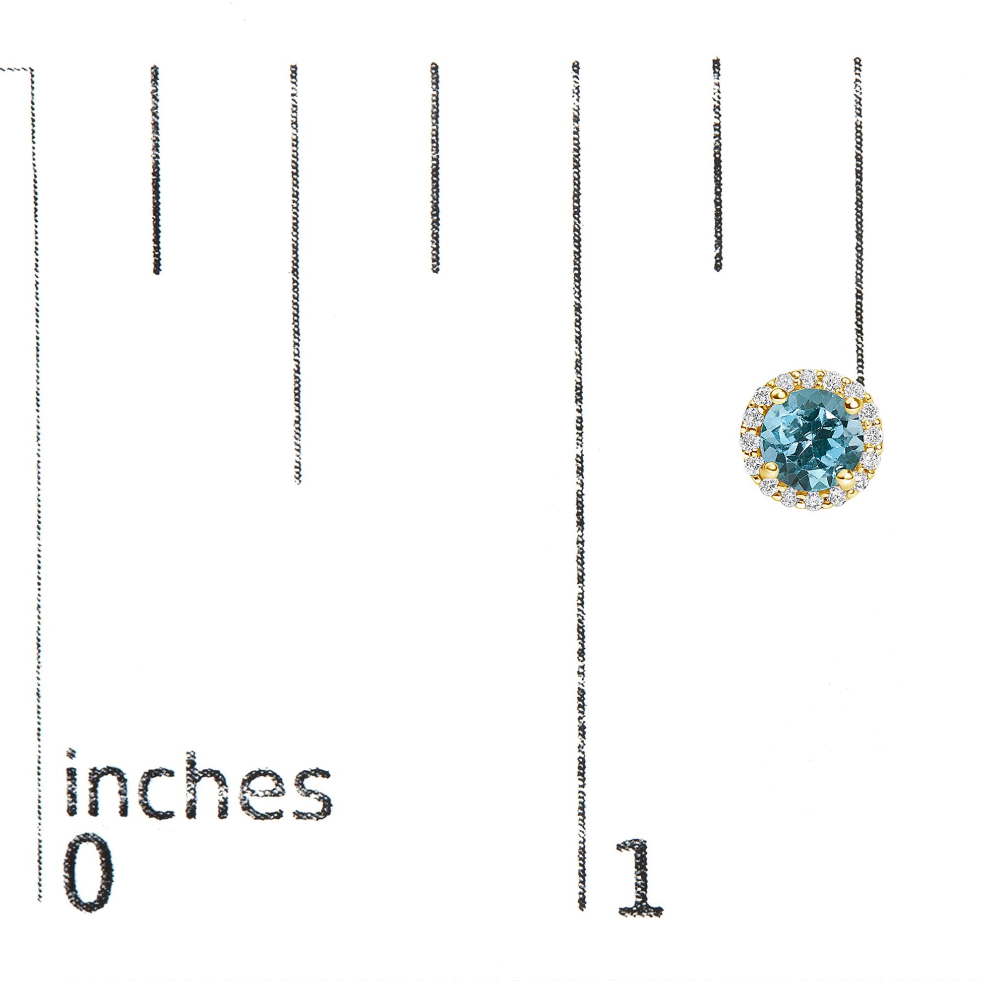 Yellow metal round earrings with a central blue gemstone surrounded by a halo of white gemstones, shown on a scale with inch measurements, front-facing angle.