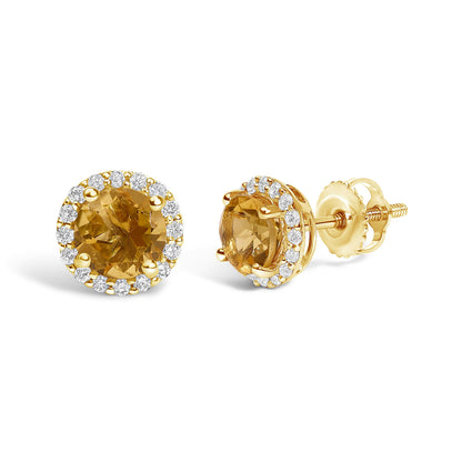 Pair of yellow metal stud earrings shown from a front and side angle, each featuring a round orange gemstone surrounded by a halo of round white gemstones in shared prong settings.