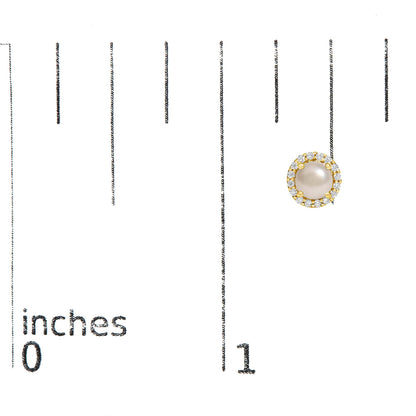 Close-up top-down view of a round yellow earring with a central pearl surrounded by a halo of white round gemstones, shown on a scale.