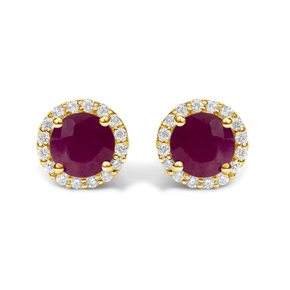 Front view of a pair of yellow metal stud earrings featuring a round red gemstone center surrounded by a halo of small round white gemstones in shared prong settings, shown on a white background.
