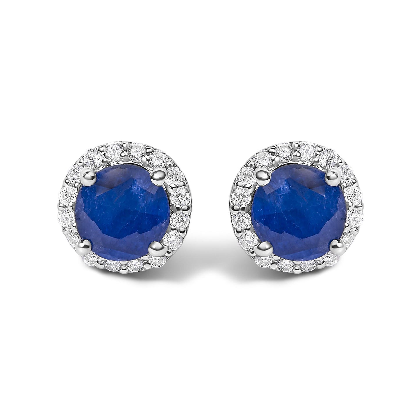 Pair of white metal stud earrings with round blue gemstones in the center, surrounded by a halo of small round white gemstones, shown in a front-facing angle on a white background.