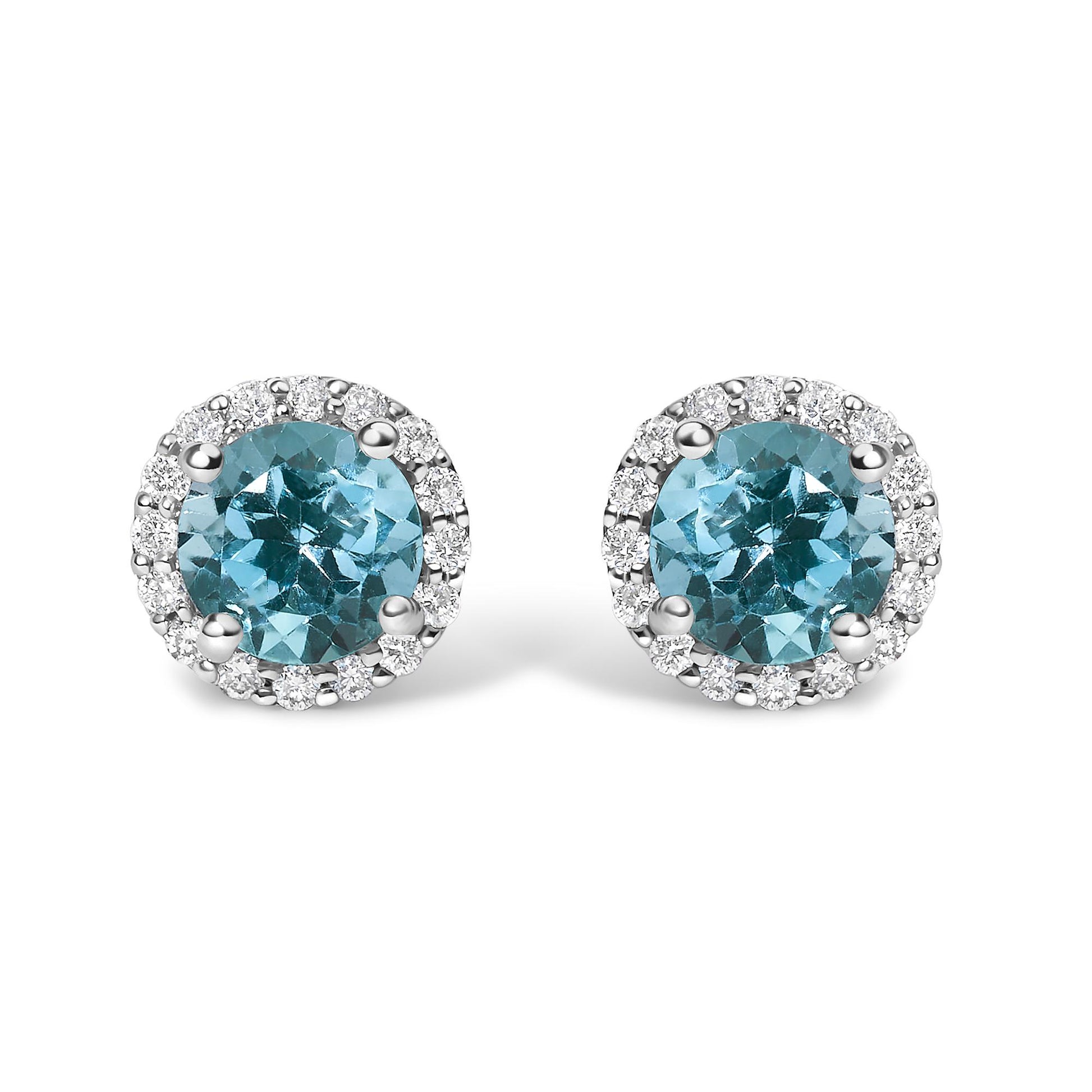Pair of white metal round stud earrings with central blue round gemstones and surrounding white round gemstones in shared prong setting, shown in a front-facing angle.