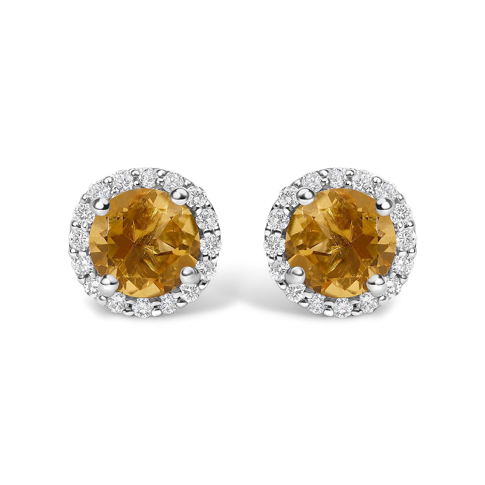 Pair of white metal stud earrings with round orange gemstones at the center, surrounded by a halo of small white gemstones, shown from a front angle on a white background.