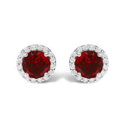 Pair of round stud earrings with red gemstones in the center, surrounded by a halo of white gemstones, shown in a front-facing close-up view.