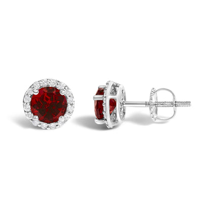 Pair of white metal stud earrings with round red gemstones in the center, surrounded by a halo of small round white gemstones, shown from front and side angles on a white background.