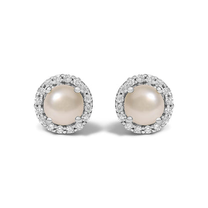 Pair of round stud earrings shown from the front on a white background, each featuring a central pearl surrounded by a halo of white round gemstones in shared prong settings on white metal.