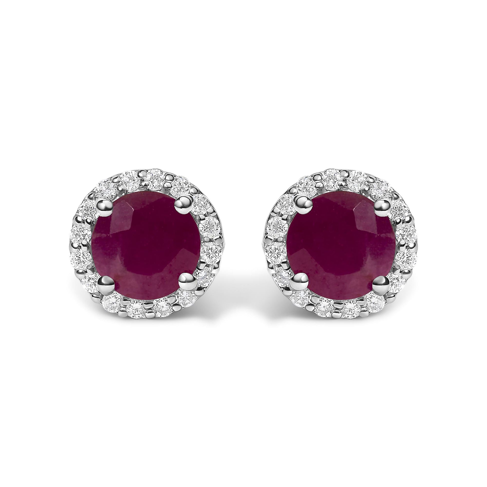 Pair of white metal round stud earrings with large red round gemstones center, surrounded by smaller white round gemstones in shared prong setting, shown in a front-facing close-up angle on a white background.
