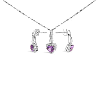 Set of white metal jewelry including a necklace with a heart-shaped purple gemstone pendant surrounded by small white gemstones, and matching earrings with heart-shaped purple gemstones and small white gemstones, shown from a front angle on a white background.