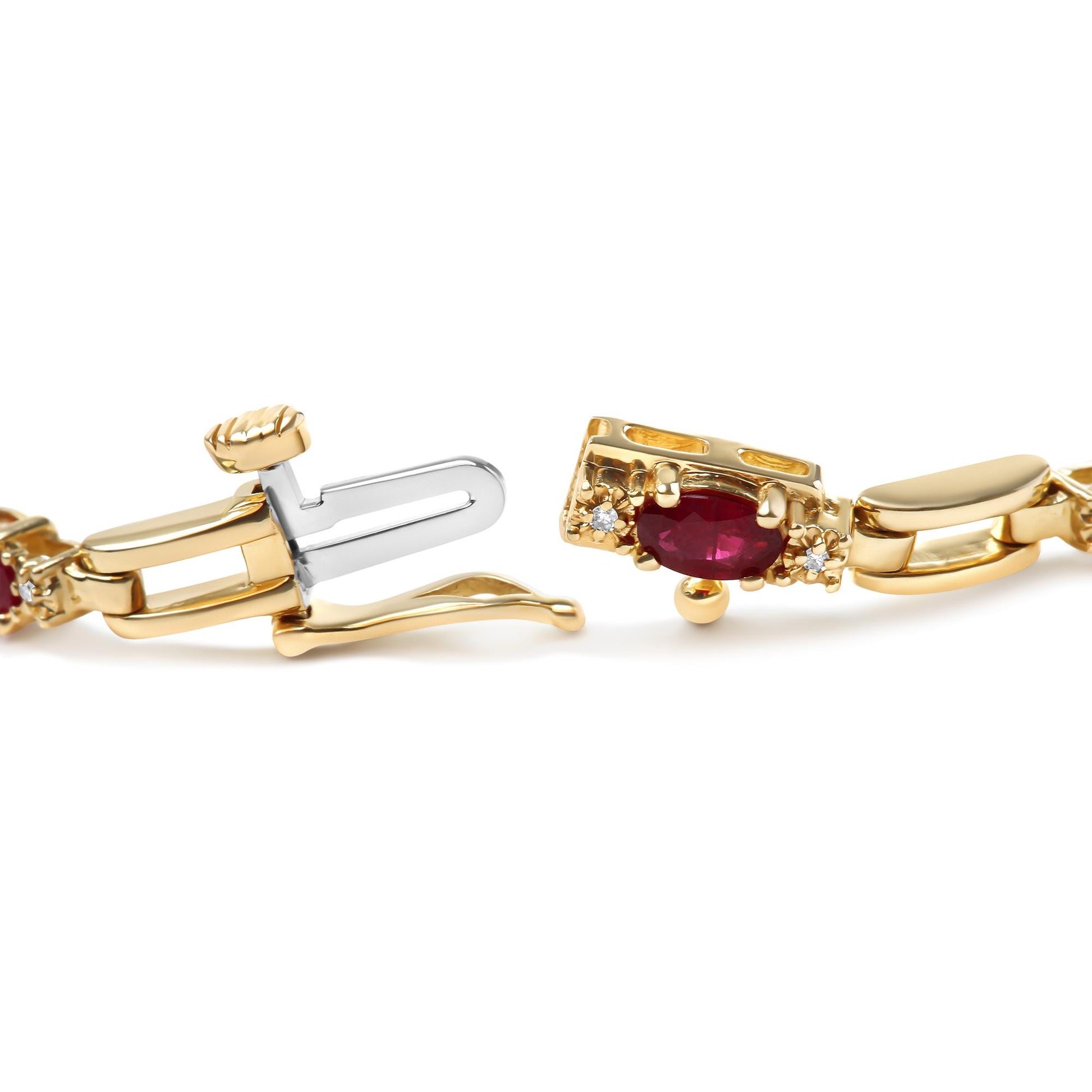 Close-up side angle of a yellow bracelet clasp featuring an oval red gemstone flanked by small round white gemstones in prong settings.